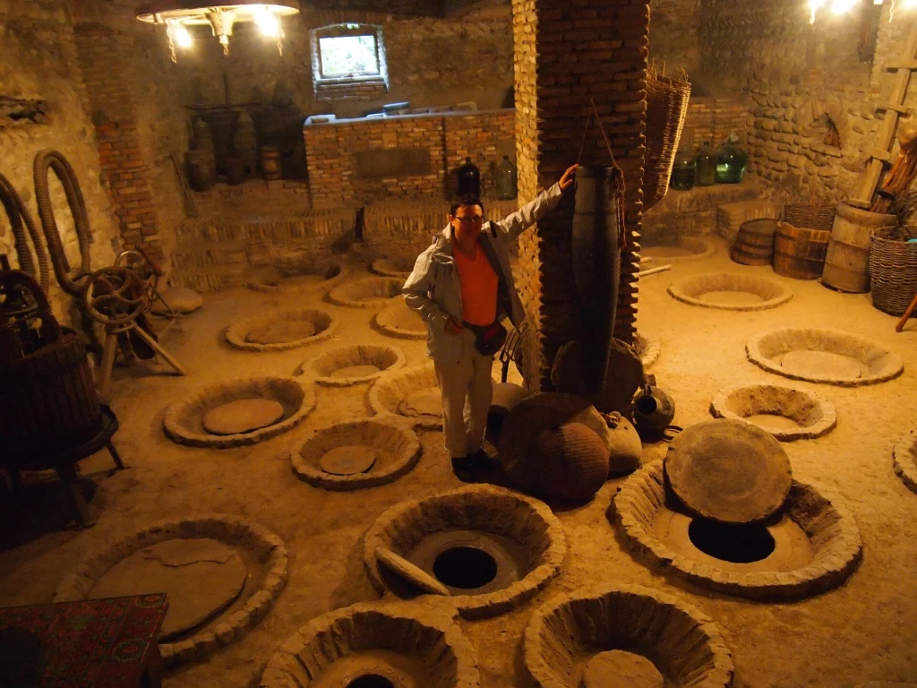 Traditional kvevri clay jugs buried in a Georgian winery, central to the country's wine culture.