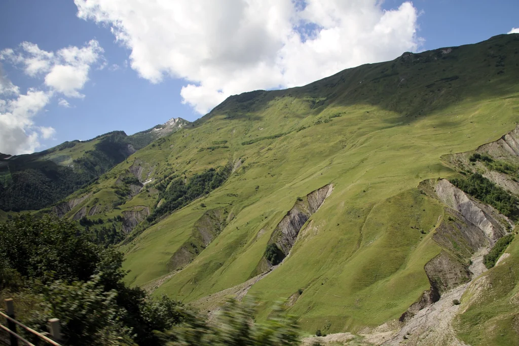 Rolling green mountains and eroded ridges seen from the Georgian Military Road.