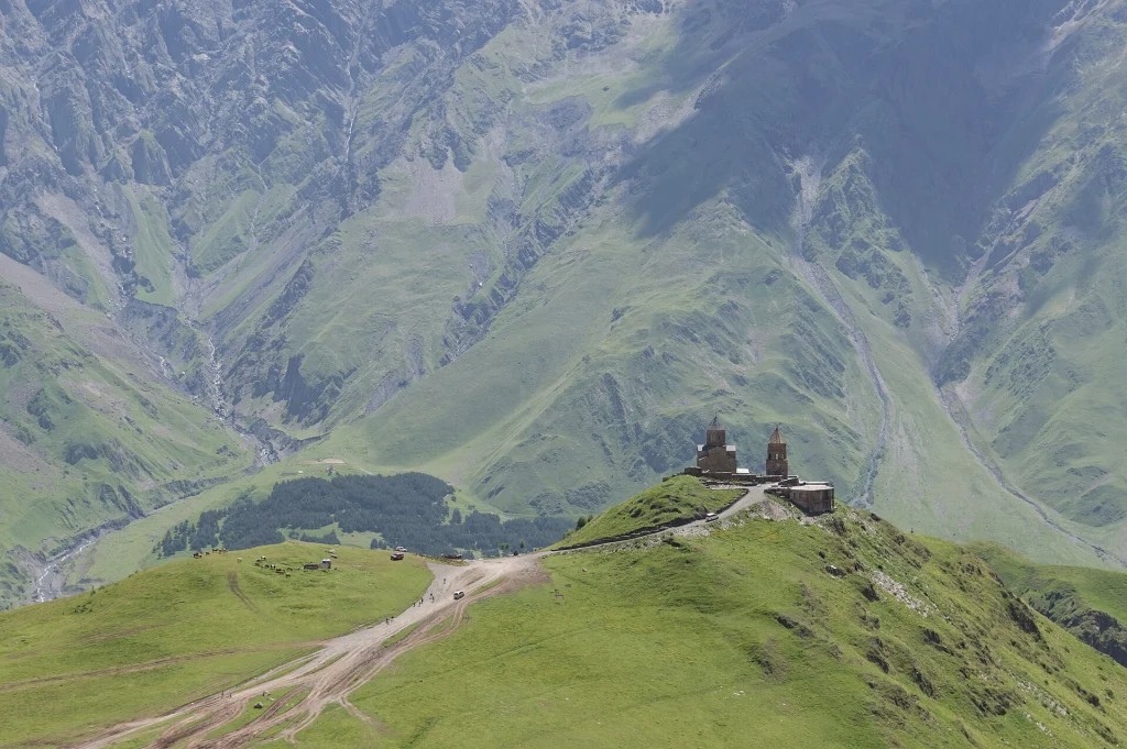 Gergeti Trinity Church perched on its hill against the Caucasus peaks near Kazbegi.