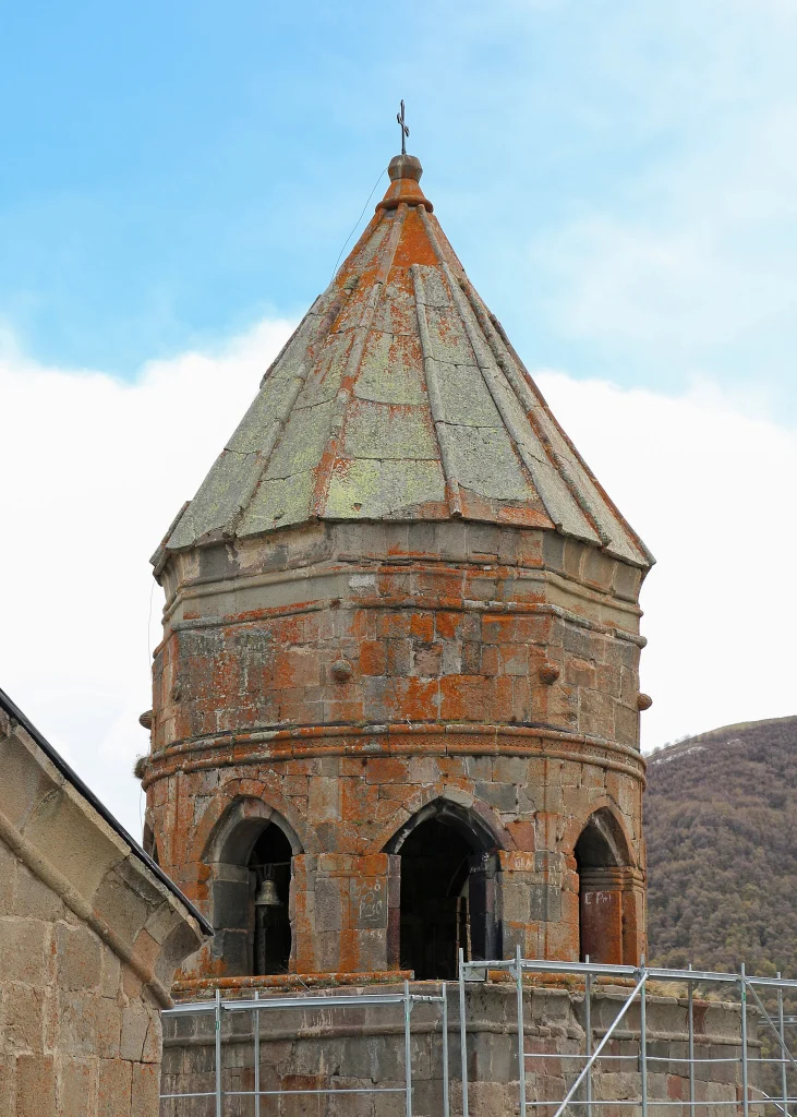 Close view of the stone bell tower and conical roof of Gergeti Trinity Church.