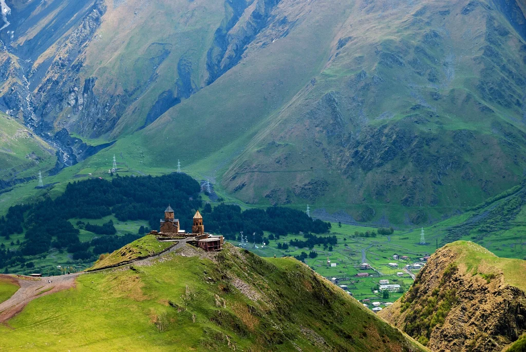Gergeti Trinity Church perched above the green Caucasus valley, a top Georgia sightseeing stop.