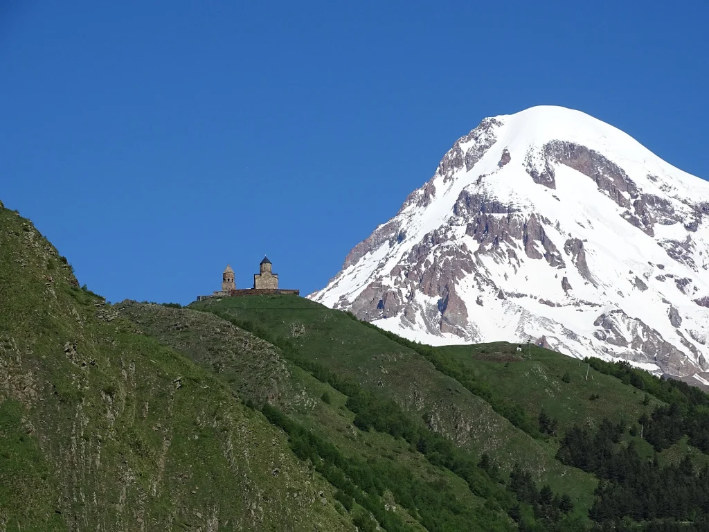 Gergeti Trinity Church framed by snow-capped Mount Kazbek, a signature Georgian landscape.