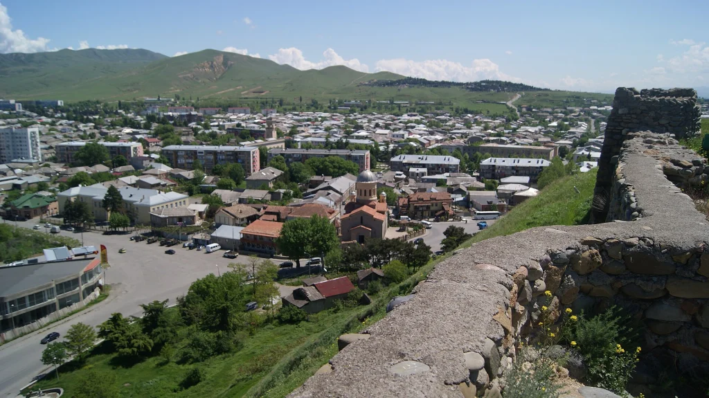 View from an old Georgian fortress over a town and surrounding hills, typical of Georgia's landscapes.