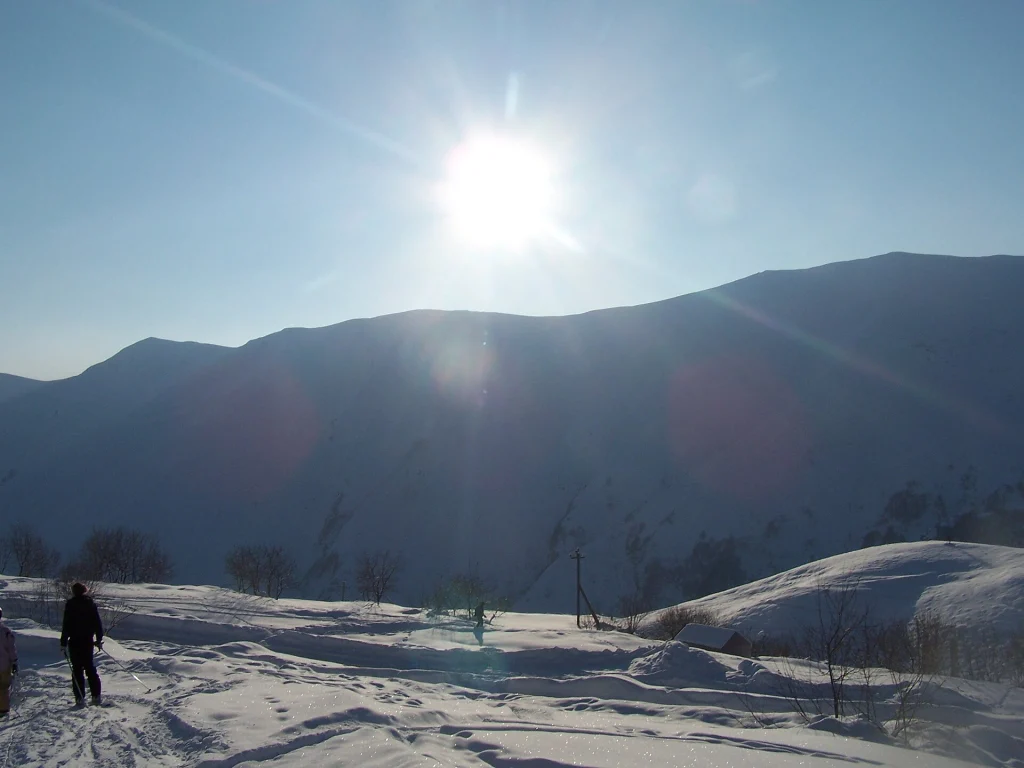 Sunlit snowy slopes and mountain ridge overlooking the Gudauri ski area.