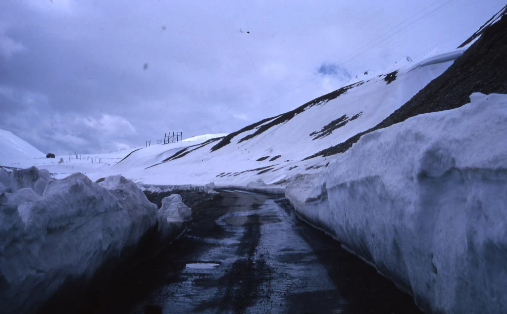 Narrow roads cut through deep snow banks highlight the risks of mountain driving in Georgia.