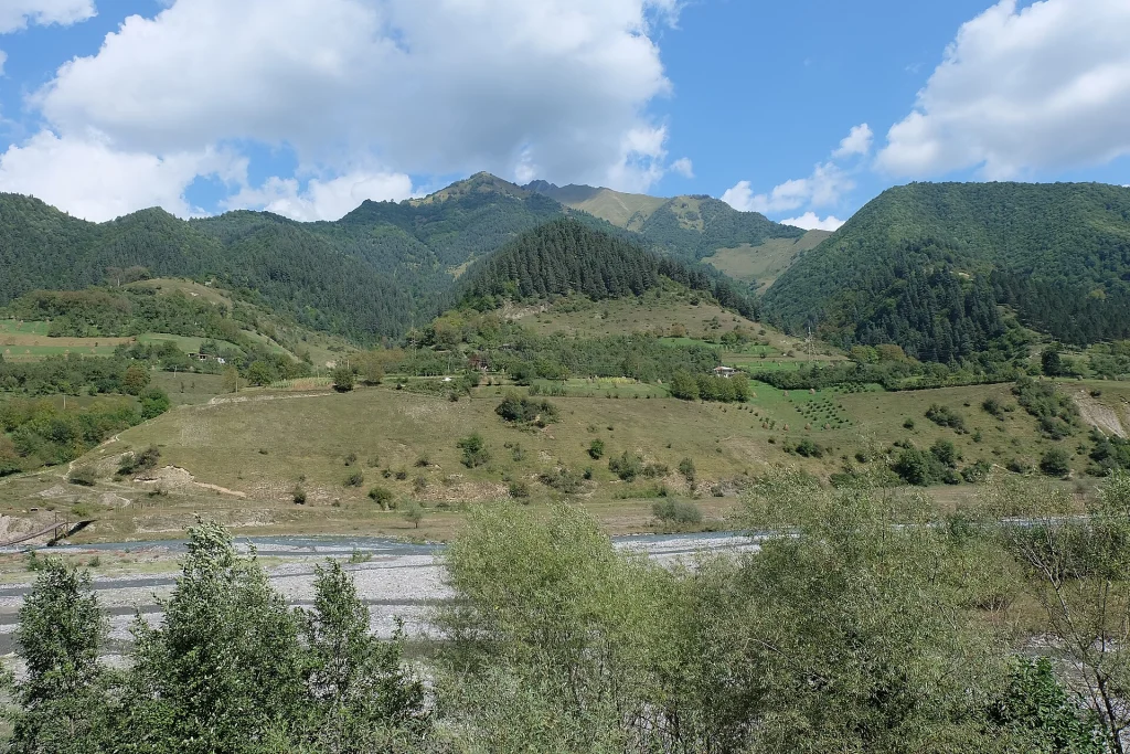 Lush green valley and river along the Georgian Military Highway toward Kazbegi.