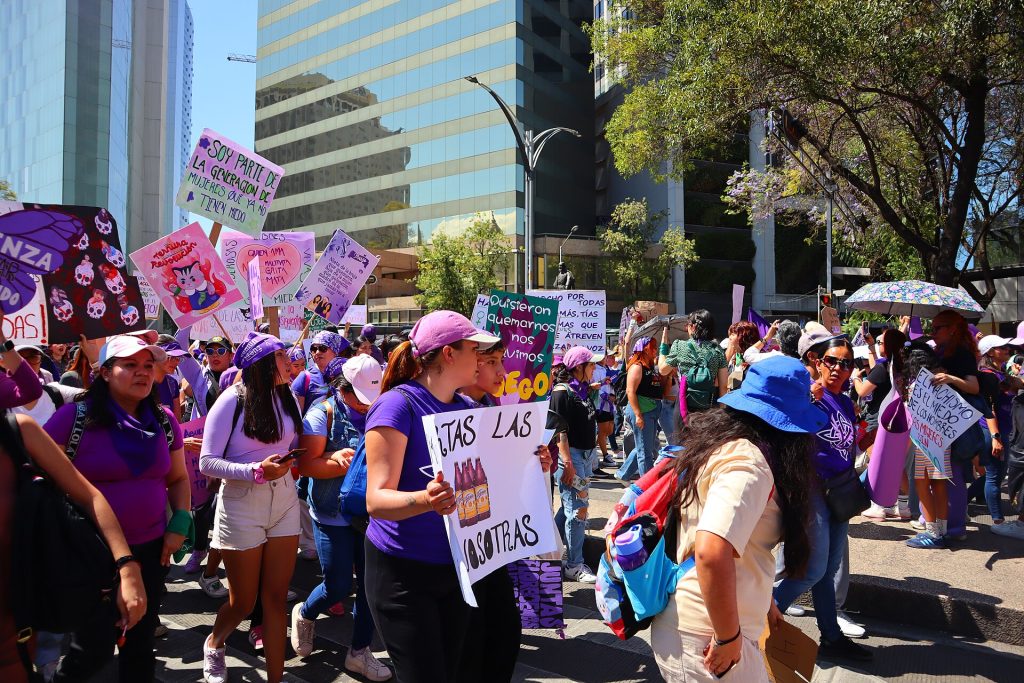 Marchers carrying placards fill the street during an International Women's Day demonstration.