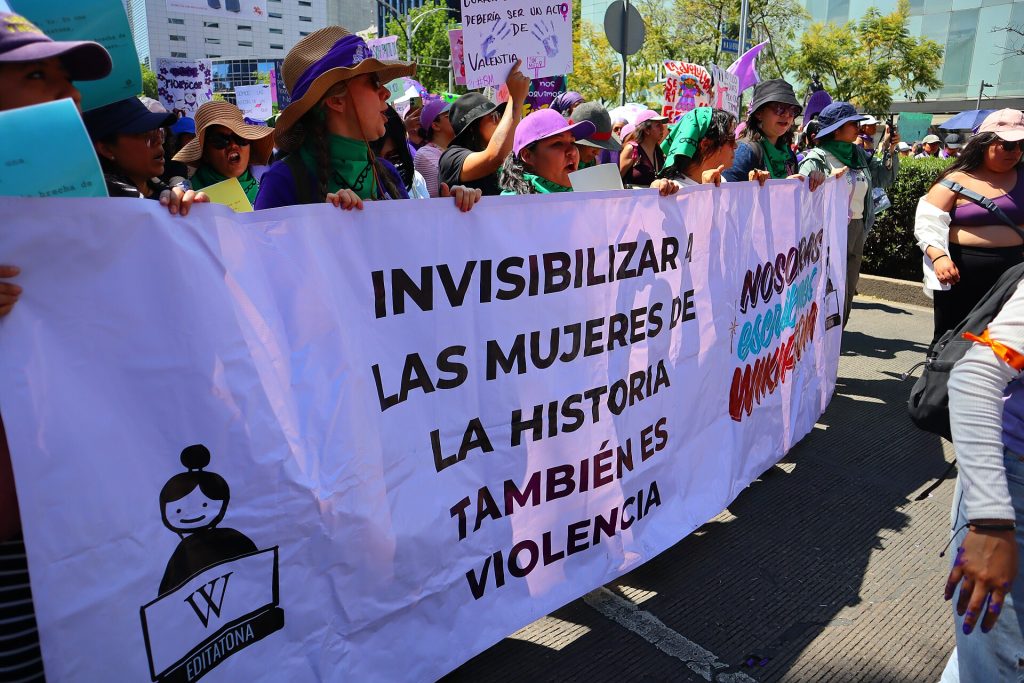 Demonstrators hold a long banner reading messages about women's rights during the march.