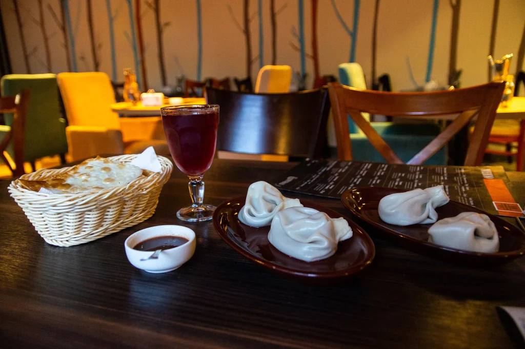 Khinkali dumplings with satsebeli sauce and a glass of Georgian red wine, a classic pairing.
