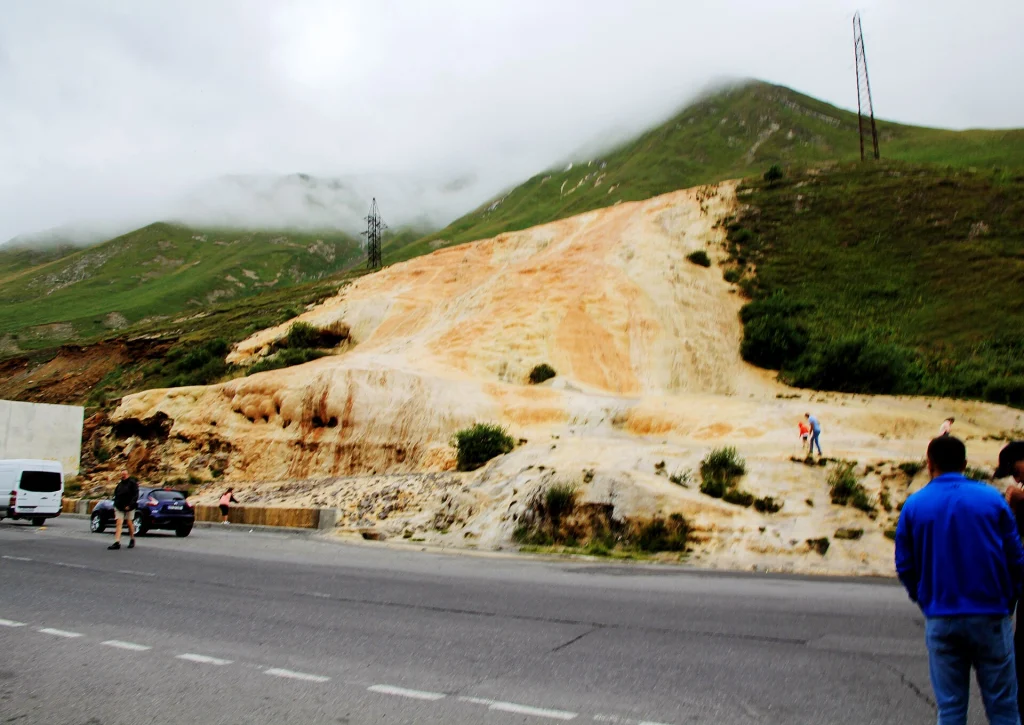 Travelers stop their cars to view the mineral travertine formations along the Jvari Pass road.