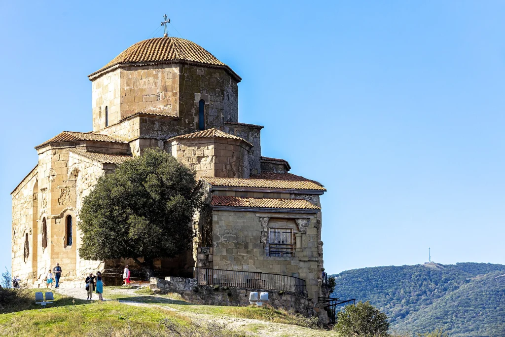 Visitors pause at the entrance of sixth-century Jvari Monastery, a key site for dress etiquette.