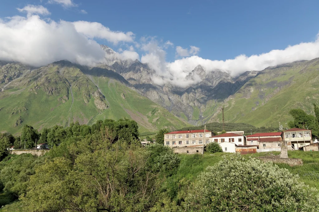 The Kuro Range mountains rise above the valley near Stepantsminda, the gateway to Gveleti.