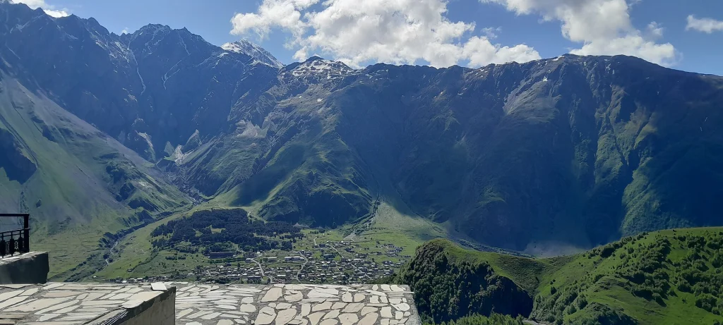 Panoramic view of the Kazbegi valley and surrounding Caucasus peaks, a highlight for travellers.