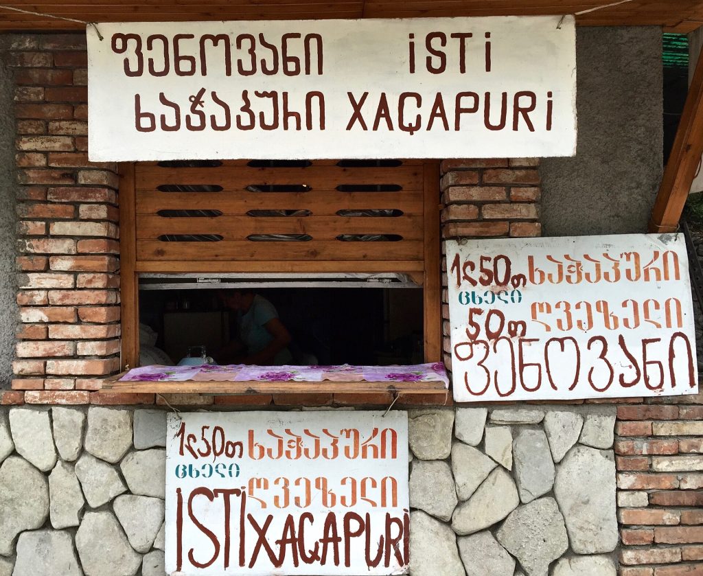 A street stall in Georgia selling freshly baked khachapuri, showing the everyday culture behind the holiday.
