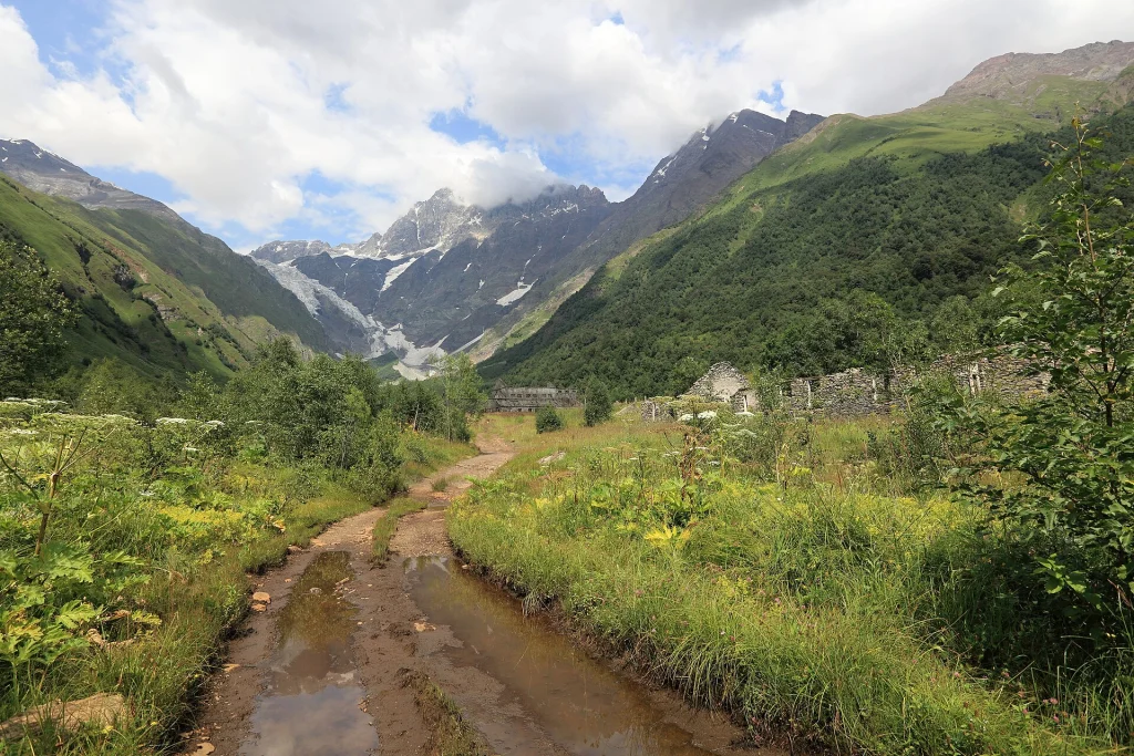 Dirt track and stream leading toward glaciated peaks near the Zagar Pass.