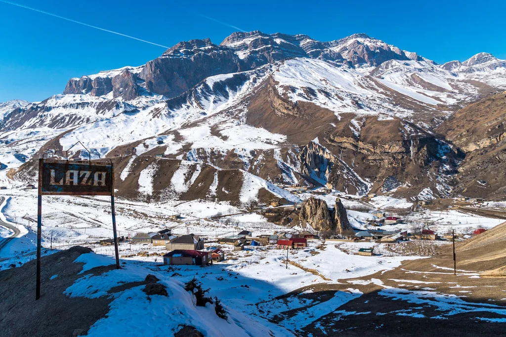 Snow-capped mountain village in the Georgian Caucasus, a typical trekking destination requiring extra travel vaccinations.