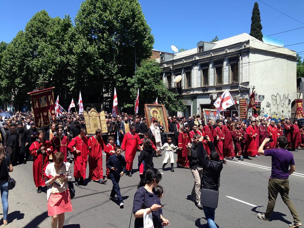 Crowds follow icon-bearing clergy down a Tbilisi street during the May 17 procession.