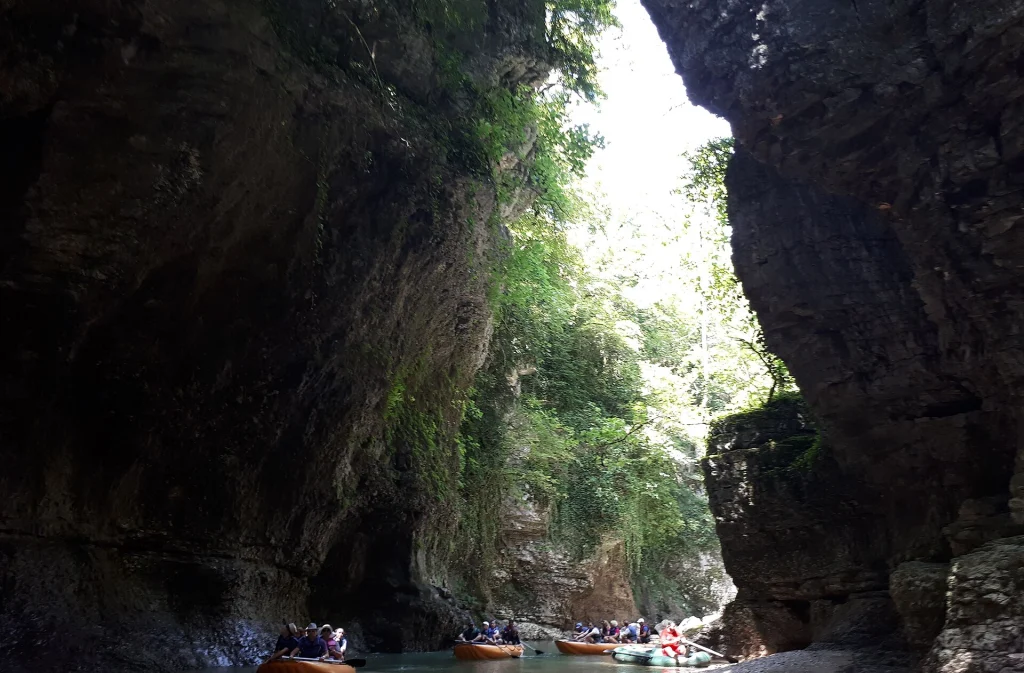 Tourists boating through Martvili Canyon, a popular nature excursion from Tbilisi.