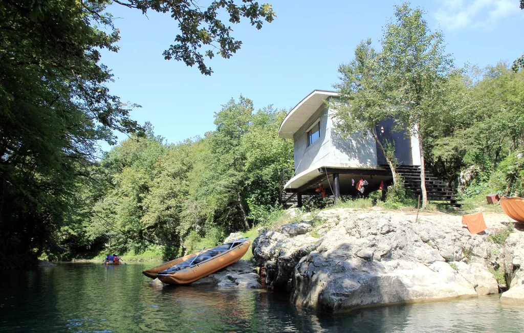 Starting point for boat trips on Martvili Canyon, with kayaks moored by the riverbank.
