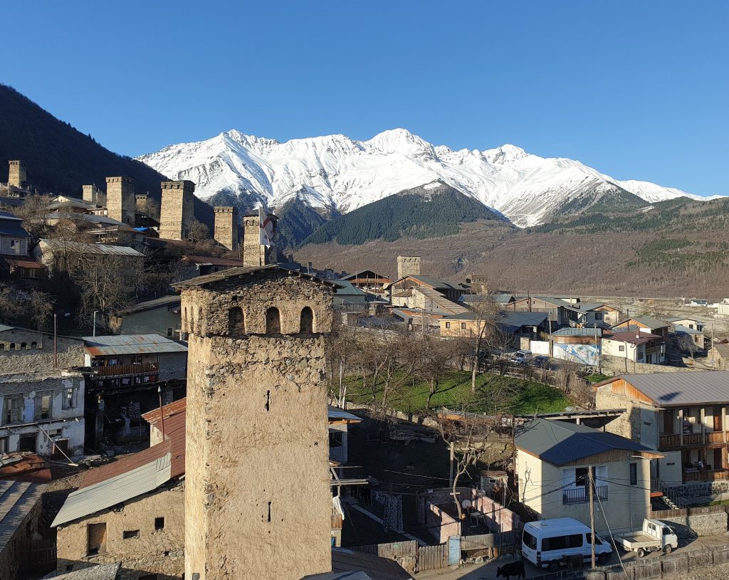 Mestia's iconic Svan tower houses beneath snow-capped peaks, the setting for Svaneti Day.