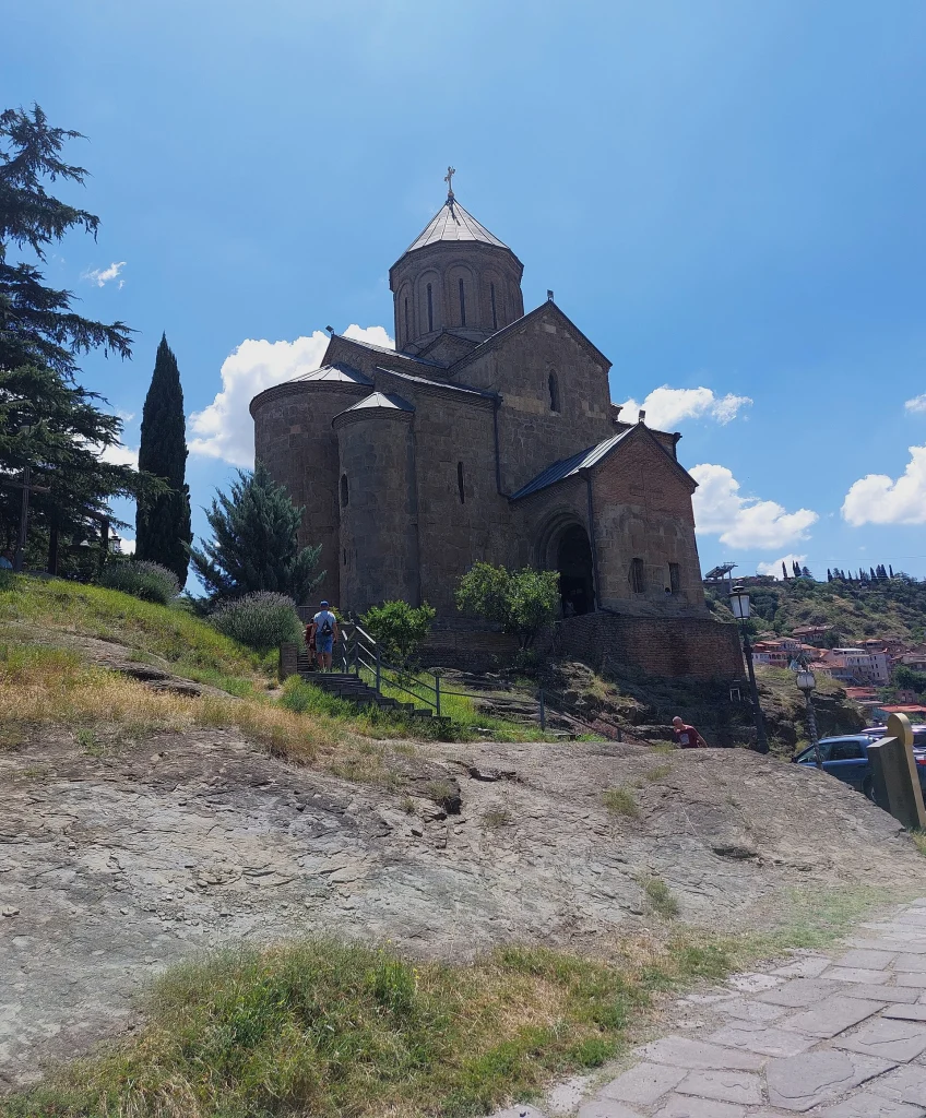 Visitors walk up to Metekhi Church, a landmark travellers often visit when exploring Tbilisi.