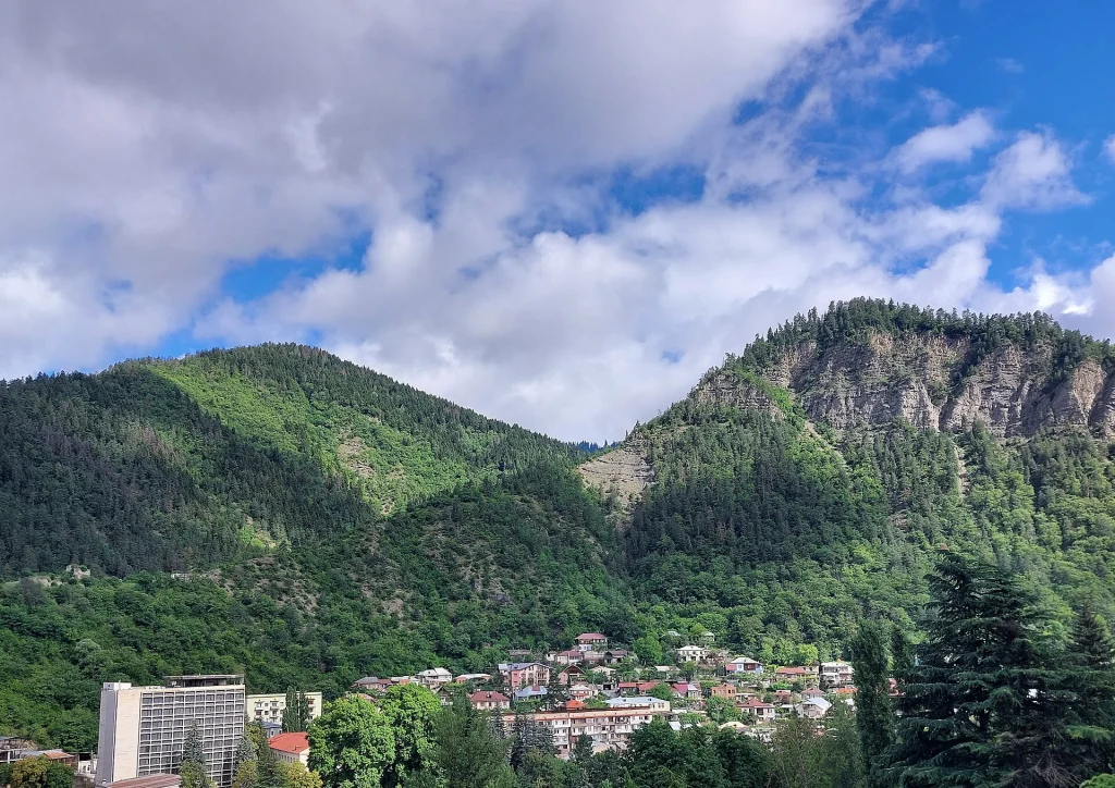 Forested mountains surrounding the town of Borjomi under a bright blue sky.