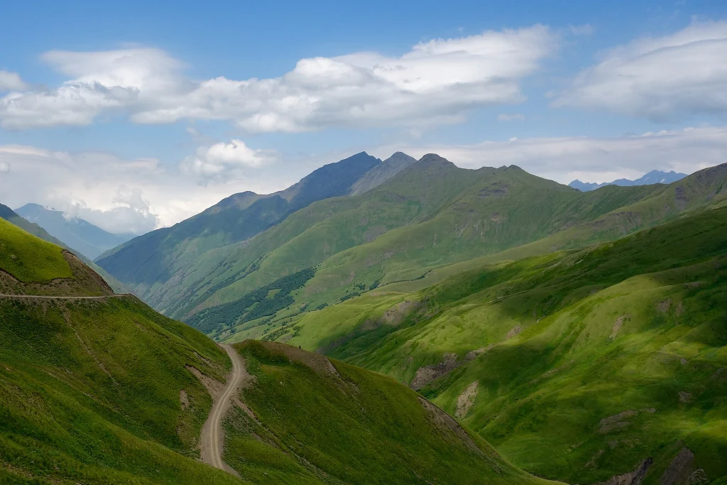 Mount West Chaukhi rises beyond a winding mountain track near Datvisjvari Pass.