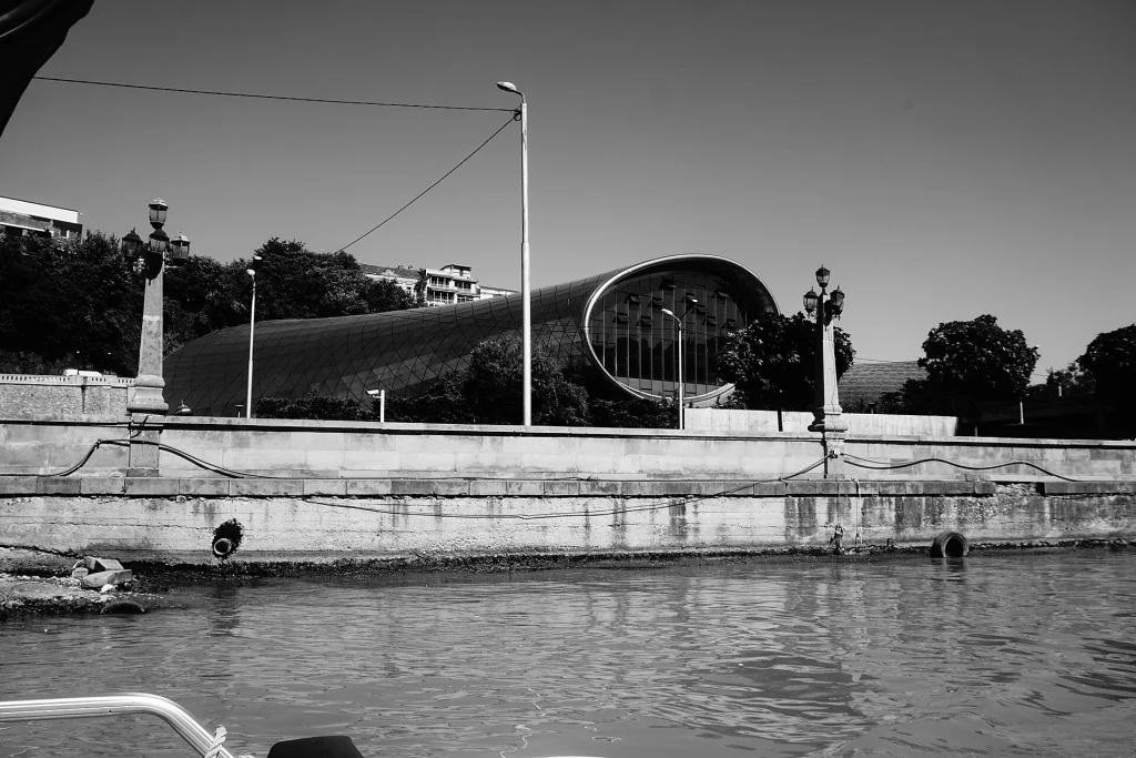 Tbilisi cityscape along the Mtkvari River, showing modern riverside architecture.