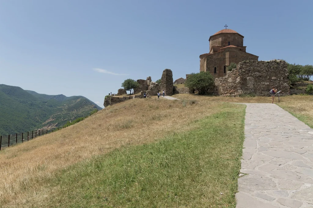 Visitors walking the grounds of Jvari Monastery, a classic Georgian heritage landmark.