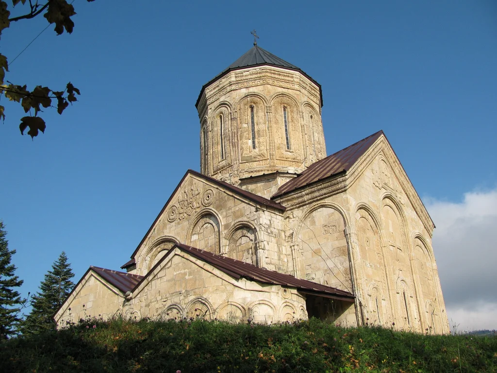 Medieval Nikortsminda Cathedral set against a clear blue sky in Racha, Georgia.