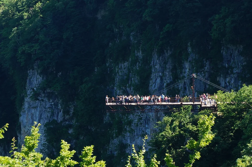 Visitors cross a suspended walkway over Okatse Canyon, a popular day-trip landscape from Tbilisi.