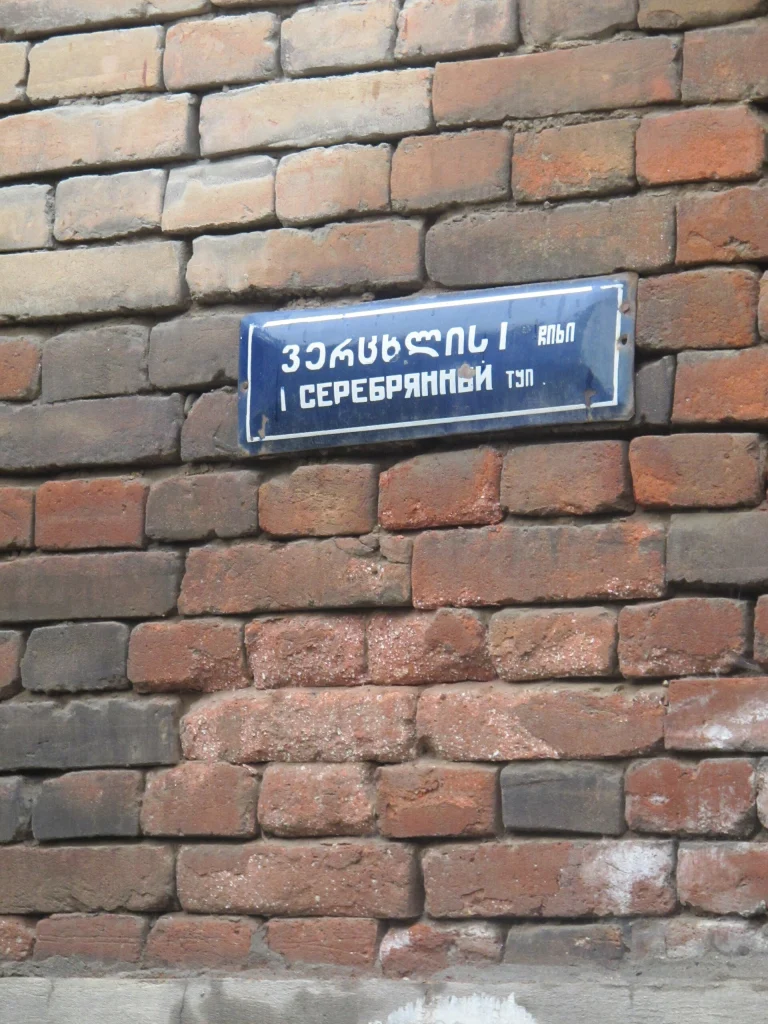 A Soviet-era bilingual Russian-Georgian street sign reflects Georgia's past reliance on Russian.