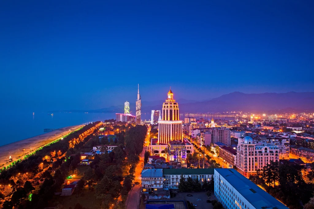 Night panorama of Batumi, Georgia, showing its illuminated seafront and towers.