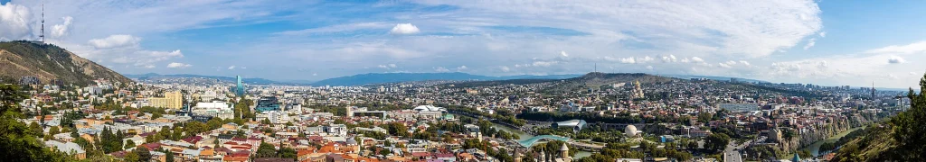 Panoramic daytime view of Tbilisi cityscape seen from Narikala hill.