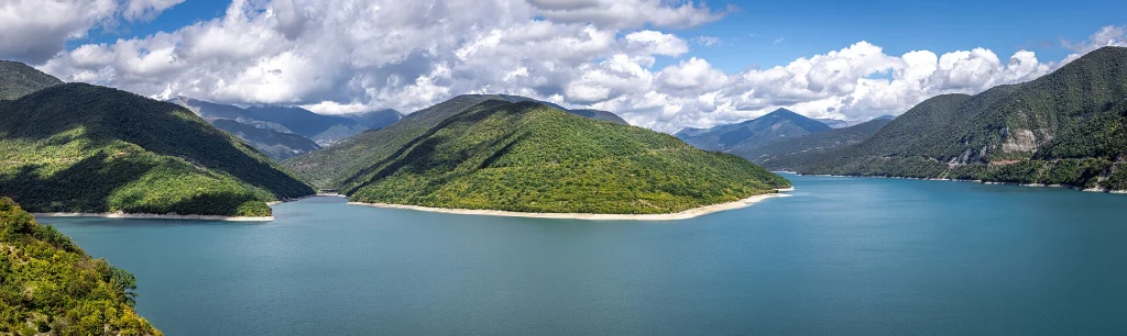 A panoramic view of Zhinvali Reservoir winding through the Caucasus Mountains.