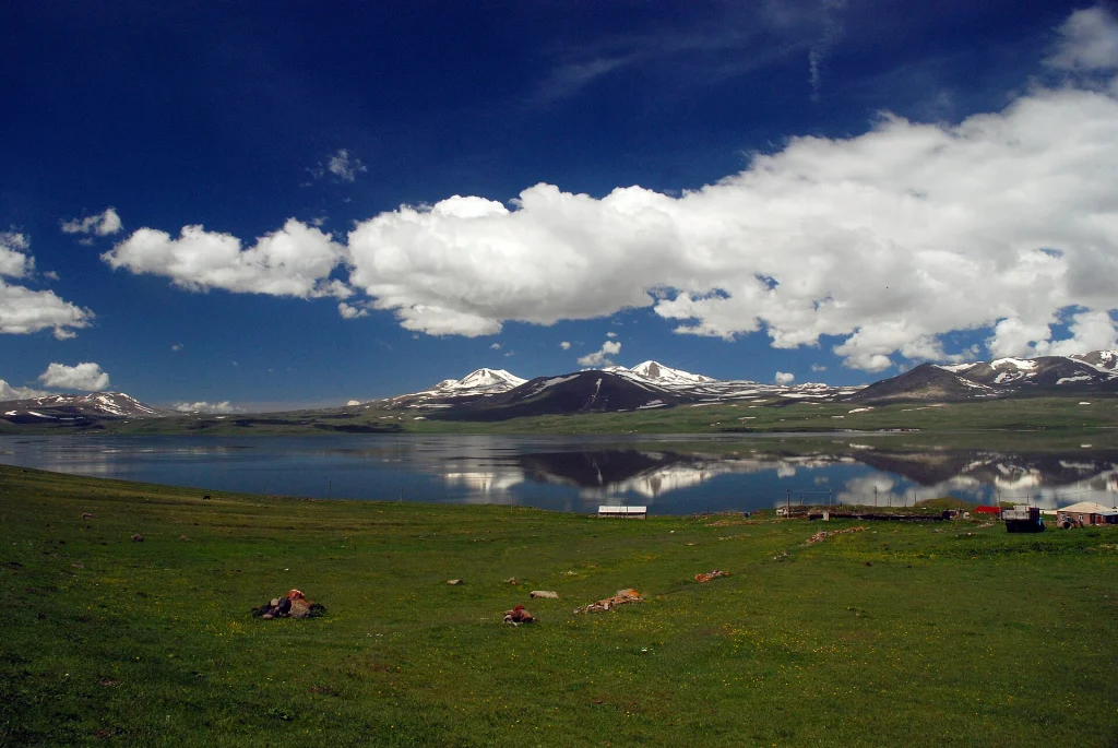 Paravani Lake reflects snow-capped peaks, a highland trout and fishing destination at 2,073 metres elevation.