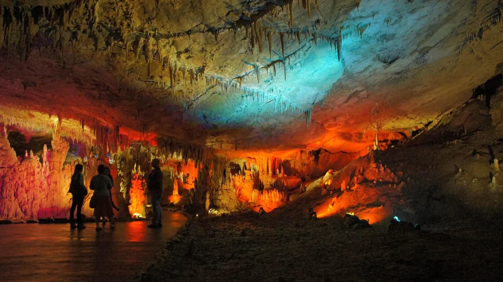 Colorfully lit stalactites and stalagmites inside Prometheus Cave near Kutaisi.