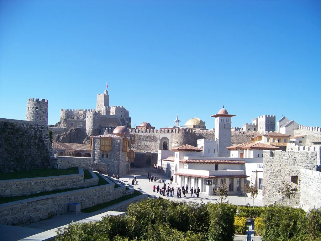 Visitors walk through Rabati Castle's courtyard beneath its towers and golden domes.