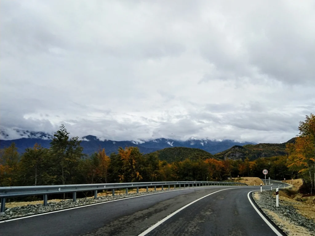 The Sachkhere–Oni road winding through autumn forest near its 1815 m pass.