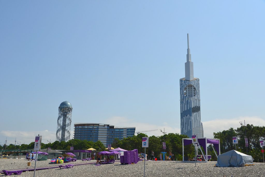 Festival tents and umbrellas set up on Batumi's seafront beneath the Alphabet Tower.