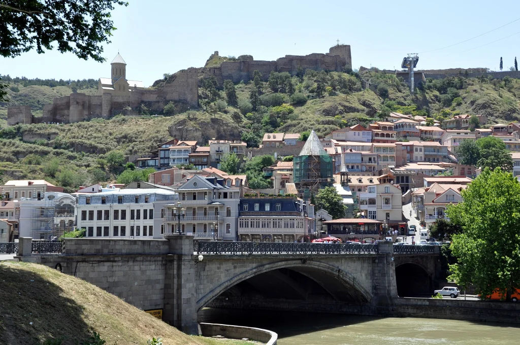 View of Tbilisi, Georgia, with the Kura River bridge and Narikala Fortress on the hill.
