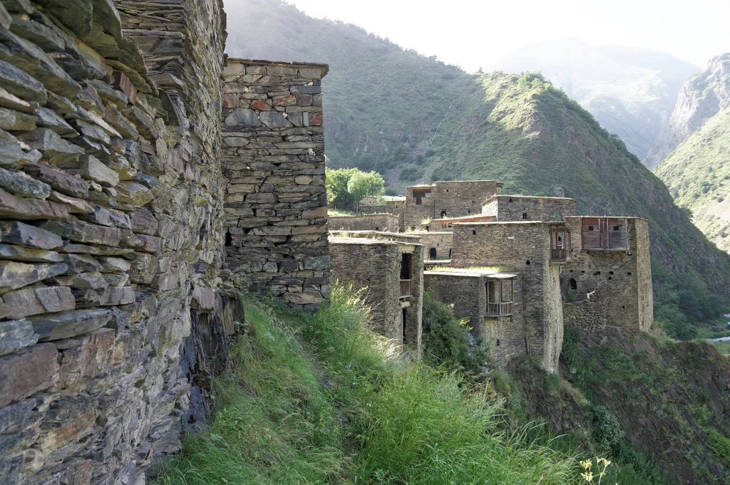 Medieval stone houses and towers of Shatili fortress clustered on a hillside in the Caucasus.