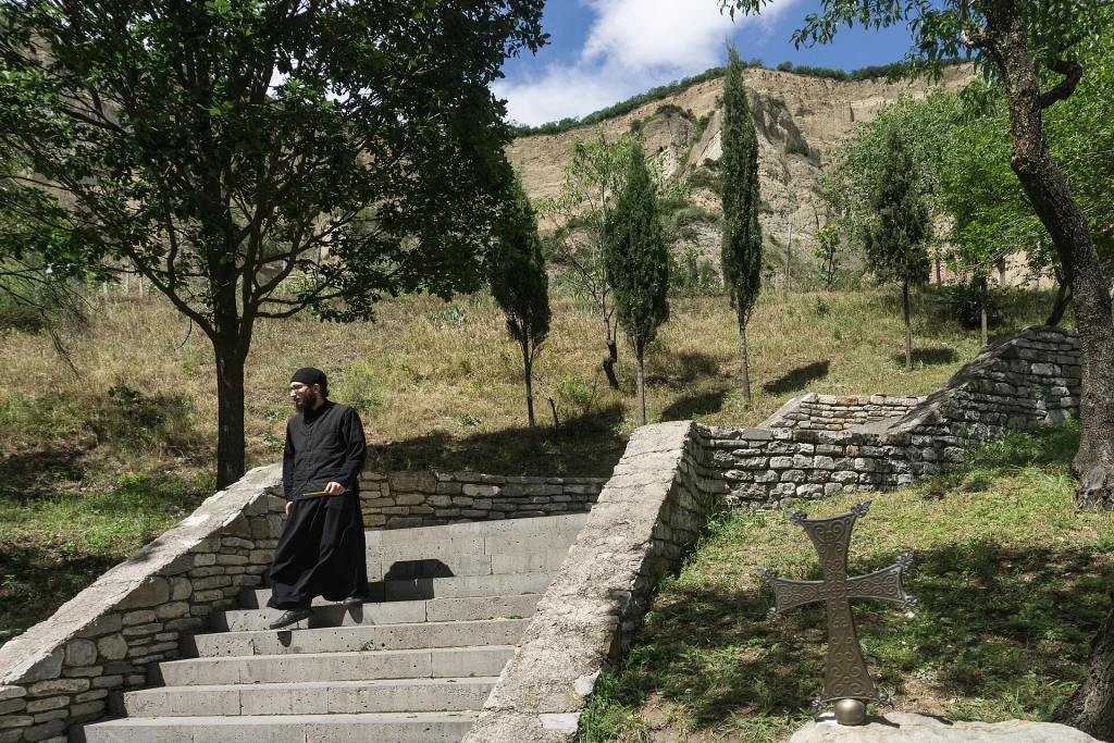 A monk descends the stone steps within the Shio-Mgvime monastery grounds.