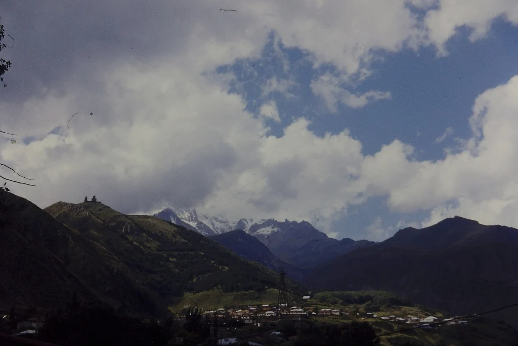 Stepantsminda beneath the Caucasus peaks, a popular July base for visiting the Kazbegi region.