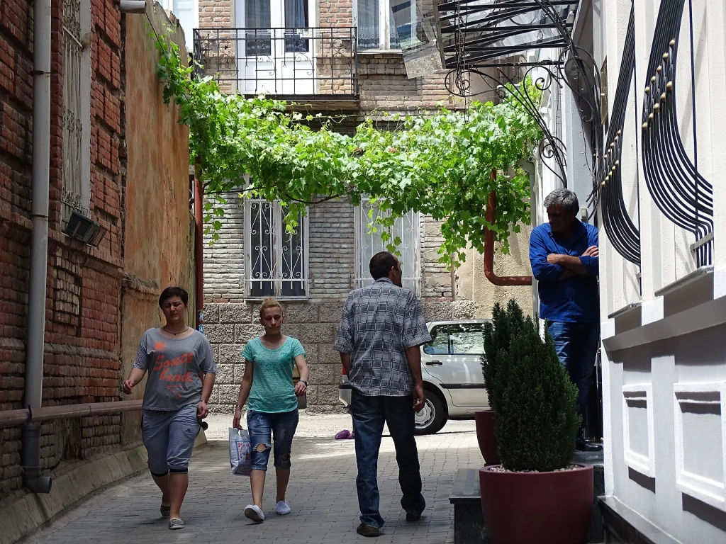 Visitors stroll a vine-shaded lane in Tbilisi's historic Old Town district.