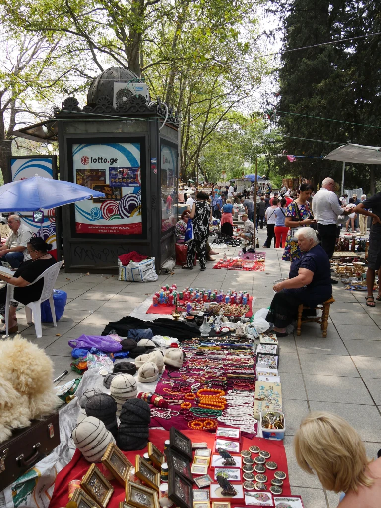 Vendors and shoppers at the lively open-air Dry Bridge flea market near the Mtkvari river in Tbilisi.