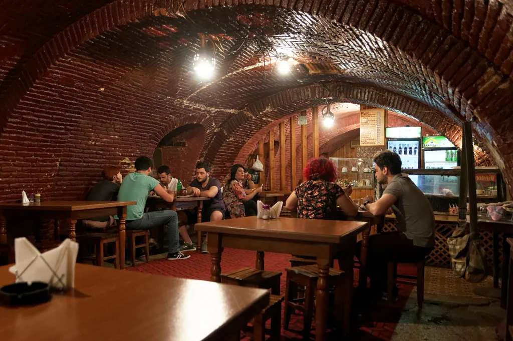Diners in a Tbilisi tavern, illustrating restaurant dining where tips are often expected.