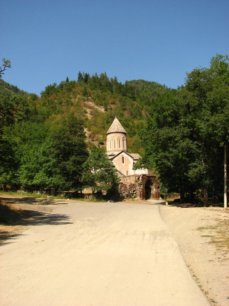 A path leads through the forest to the Timotesubani Monastery nestled in the hills.