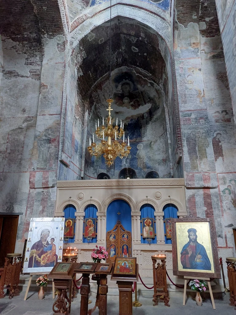 Interior view of Timotesubani Church showing its restored iconostasis and medieval frescoes.
