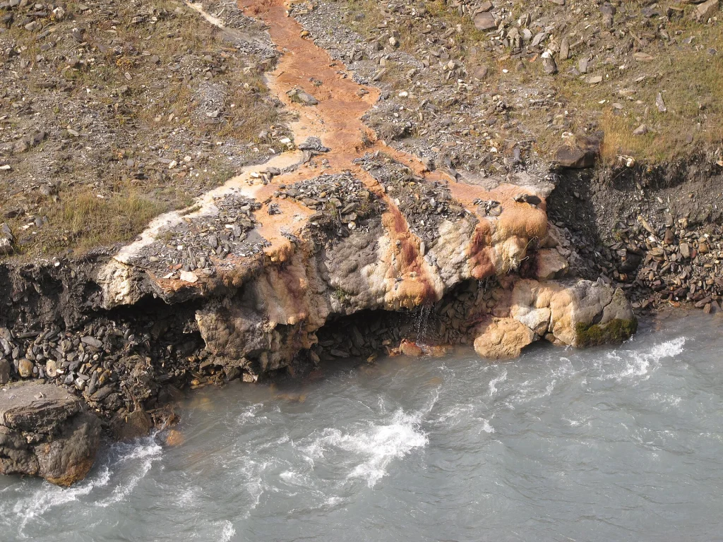 Orange mineral travertine deposits precipitate along the banks of the Terek river in Truso Valley.